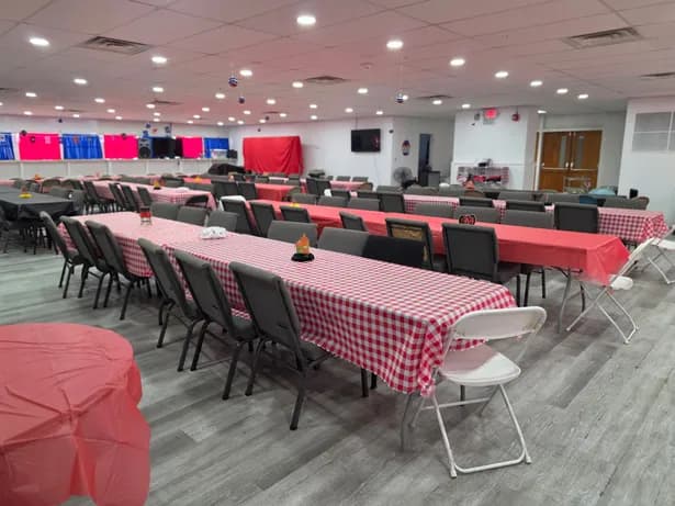 Long banquet tables with red gingham tablecloths set for an event in the Dining Hall